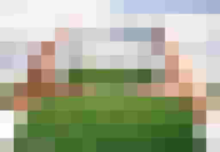 Smartphone zeigt architektonische Pläne eines Neubaus auf grüner Wiese in Salzburg.