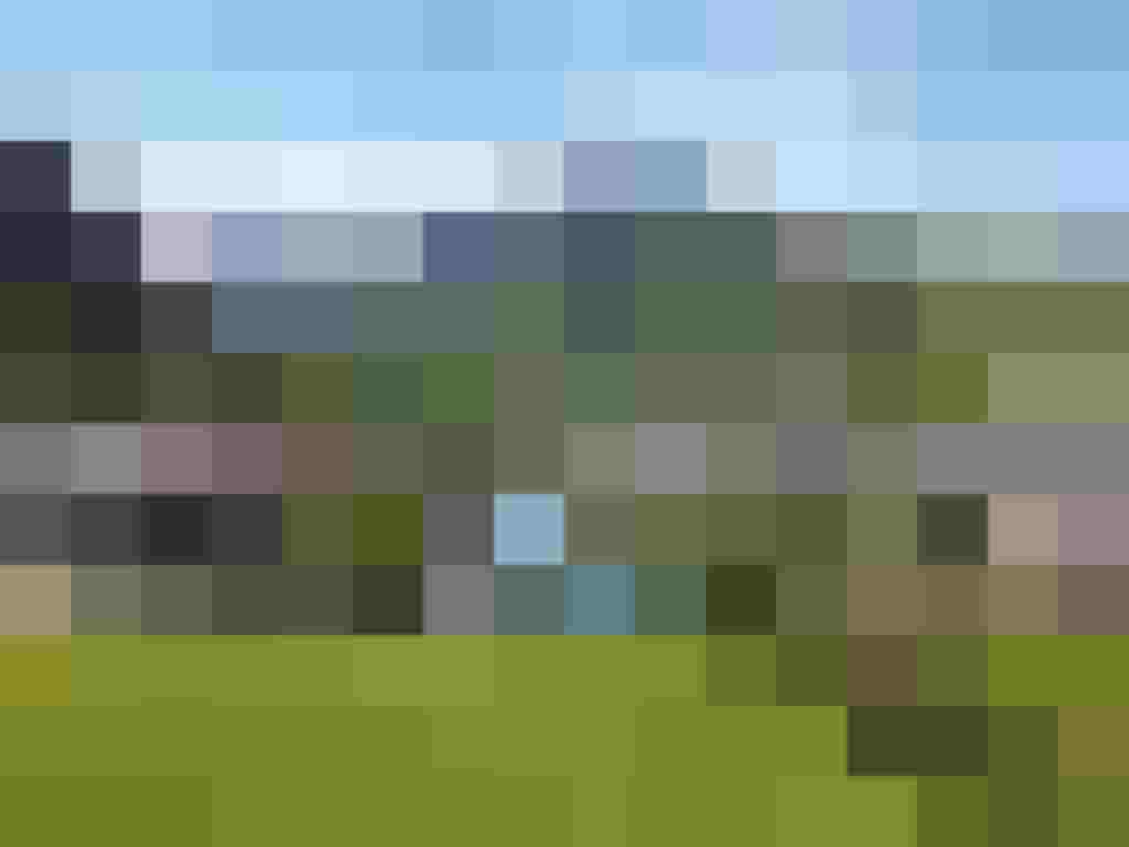 Landschaftsansicht von Kaprun mit modernen Wohnhäusern und den Alpen im Hintergrund.