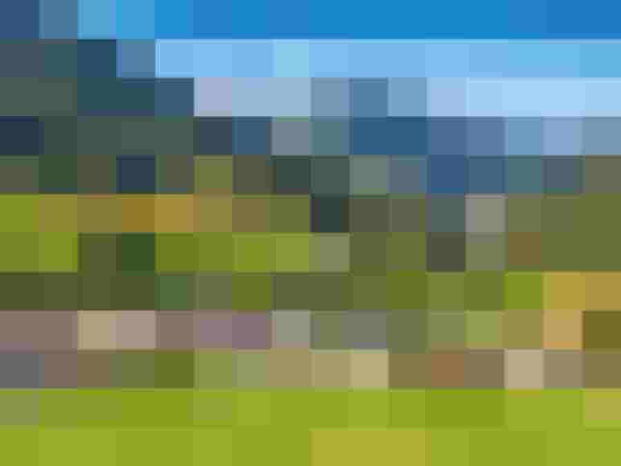 Panoramablick auf eine alpine Landschaft mit einem Dorf und umliegenden Bergen in Österreich.