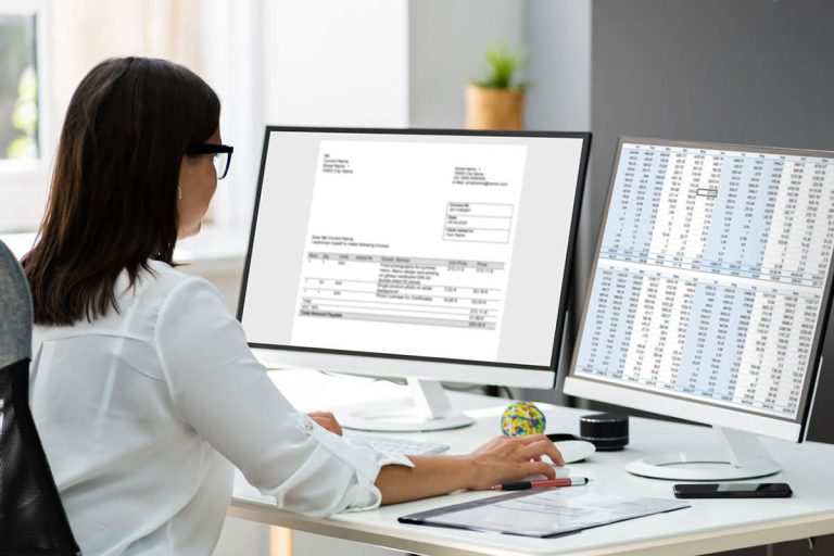 Frau arbeitet am Computer mit Buchhaltungsdaten für Wohnbau Immobilien und Neubauprojekte