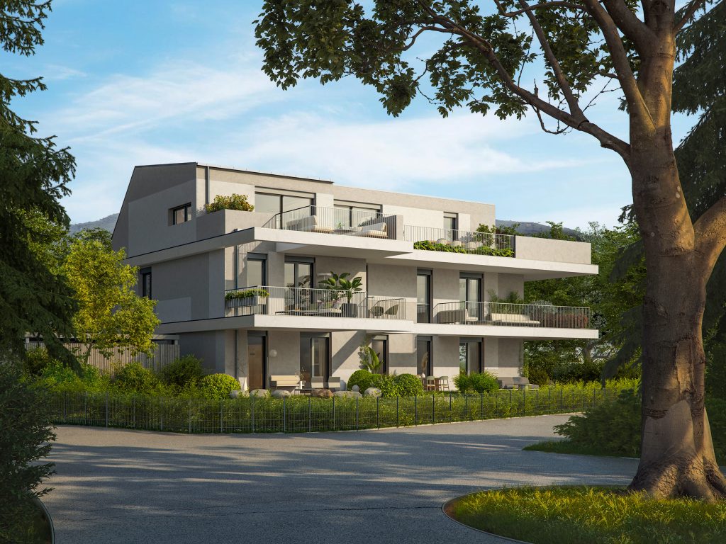 Modernes Mehrfamilienhaus mit großen Balkonen und Garten in grüner Umgebung