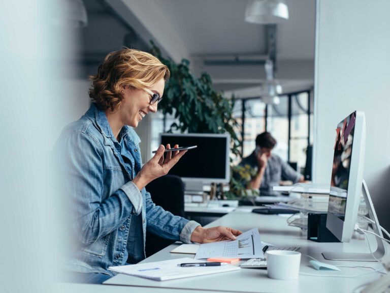 Frau telefoniert im modernen Büro am Schreibtisch