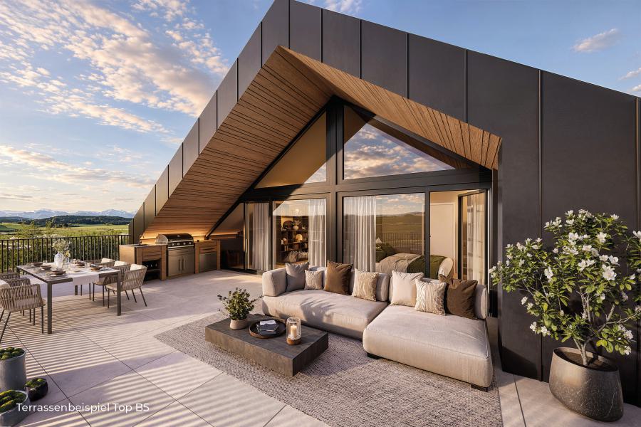 Dachterrasse mit hellem Ecksofa, Esstisch und Außenküche vor einer Glasfront mit dreieckigem Giebel